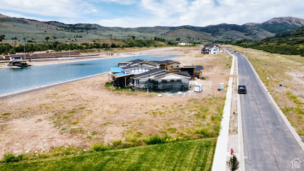 Aerial view of property and surrounding area with a water and mountain view