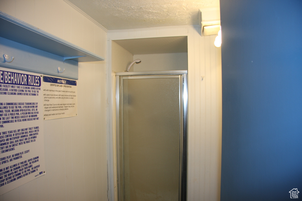 Full bathroom featuring a textured ceiling and a shower stall