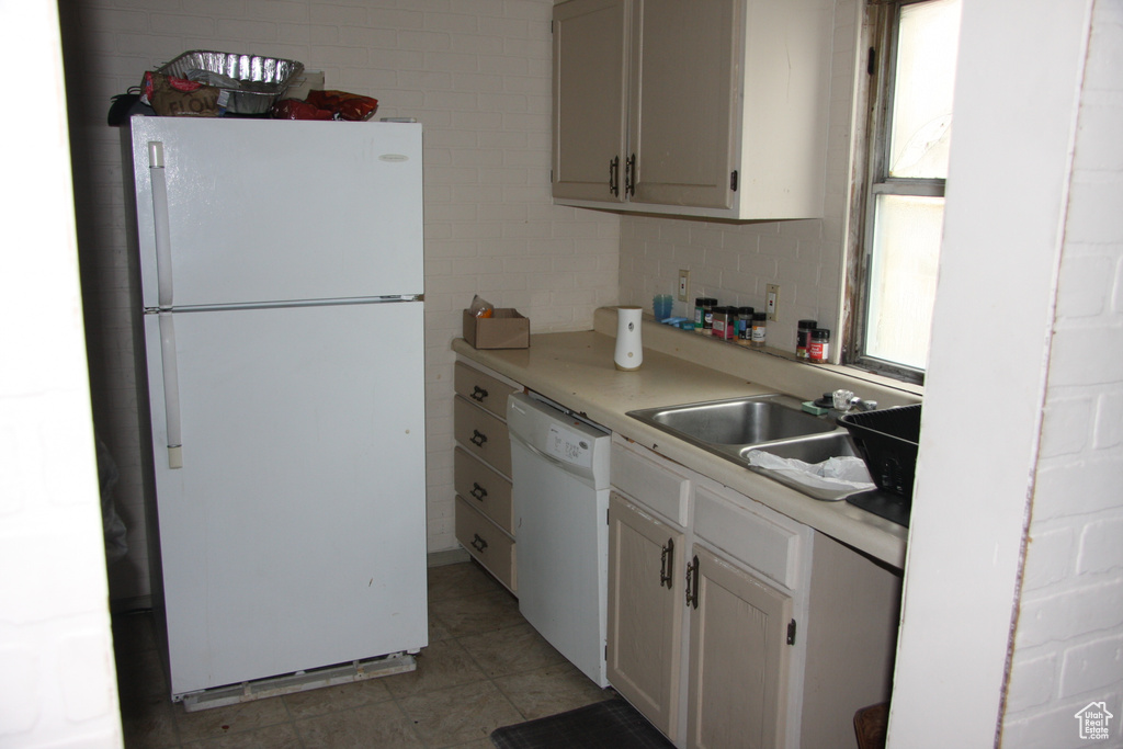Kitchen featuring white appliances, light countertops, white cabinets, and decorative backsplash