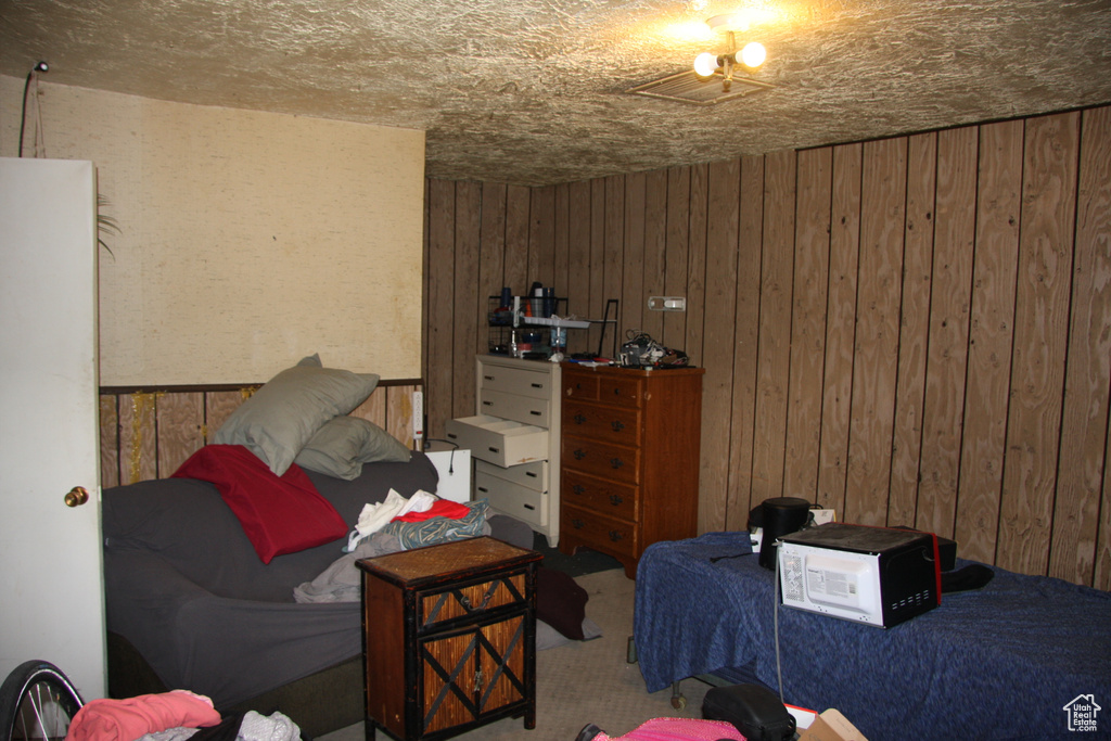 Carpeted bedroom with wood walls