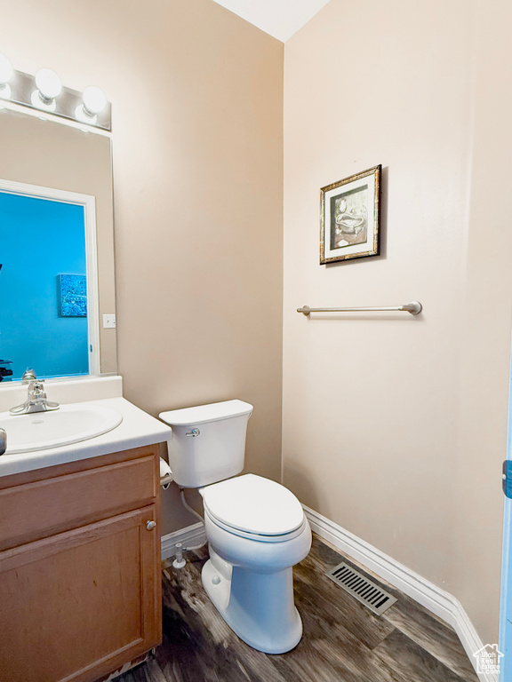 Half bathroom featuring vanity and wood finished floors
