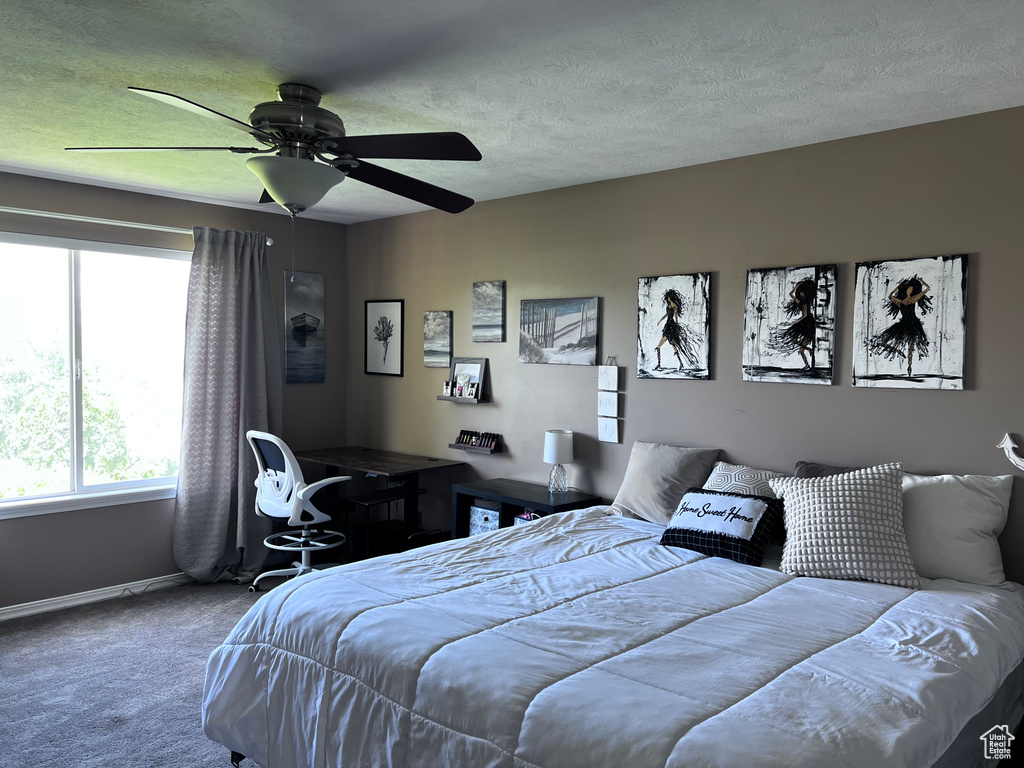 Carpeted bedroom with a textured ceiling and a ceiling fan