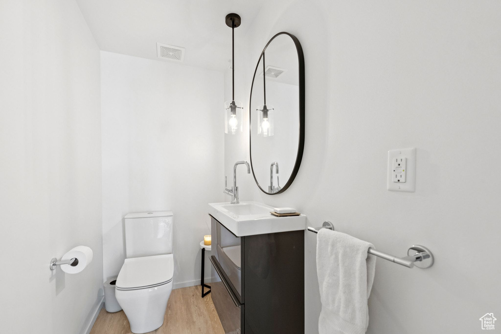 Half bath with vanity and wood finished floors
