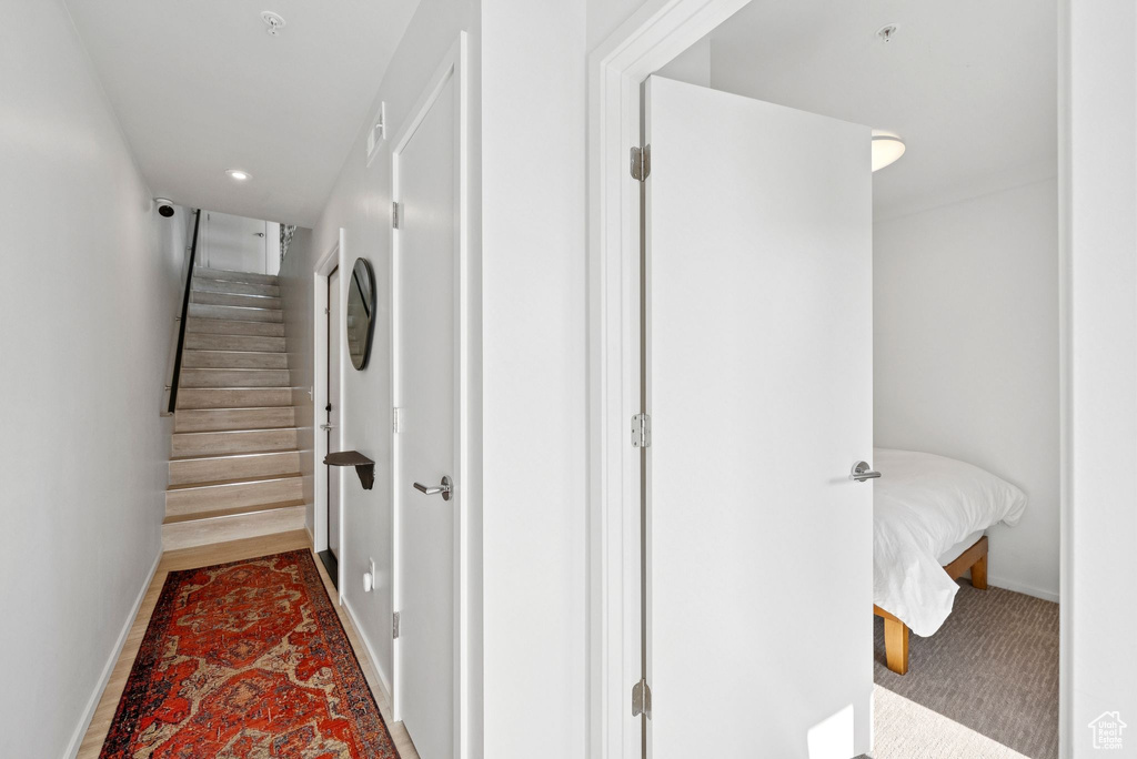 Stairs with carpet flooring and recessed lighting