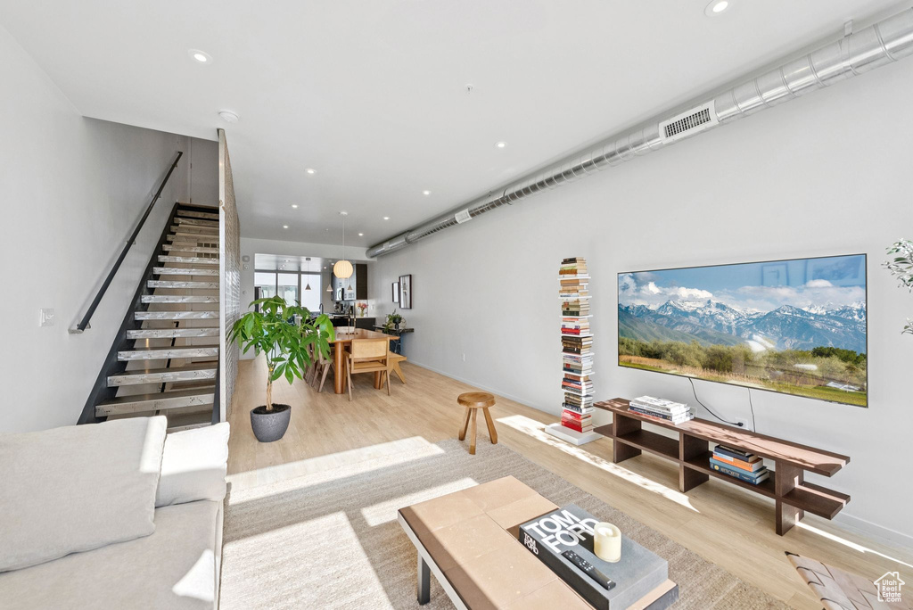 Living room featuring wood finished floors, stairway, and recessed lighting
