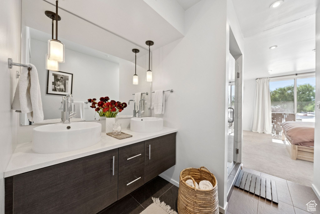 Ensuite bathroom with double vanity, a stall shower, and recessed lighting