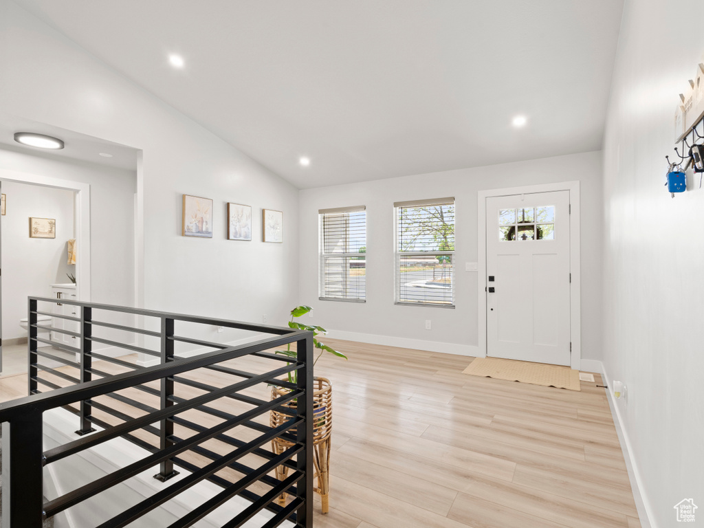 Foyer entrance with vaulted ceiling, light wood-style flooring, and recessed lighting
