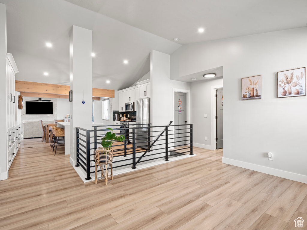 Living room with recessed lighting, light wood finished floors, and high vaulted ceiling