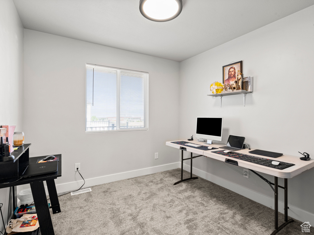 Carpeted home office featuring baseboards