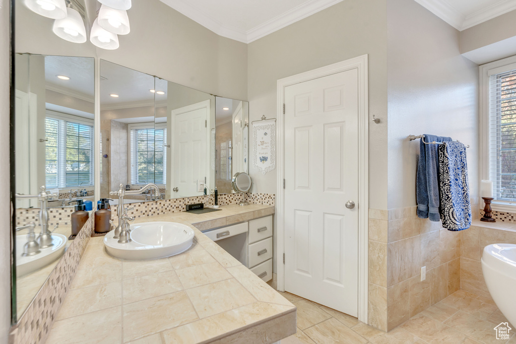 Full bath featuring ornamental molding, a soaking tub, vanity, tile patterned flooring, and a stall shower