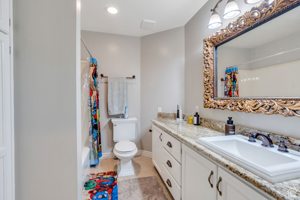 Bathroom featuring vanity, shower / bath combo with shower curtain, and tile patterned floors