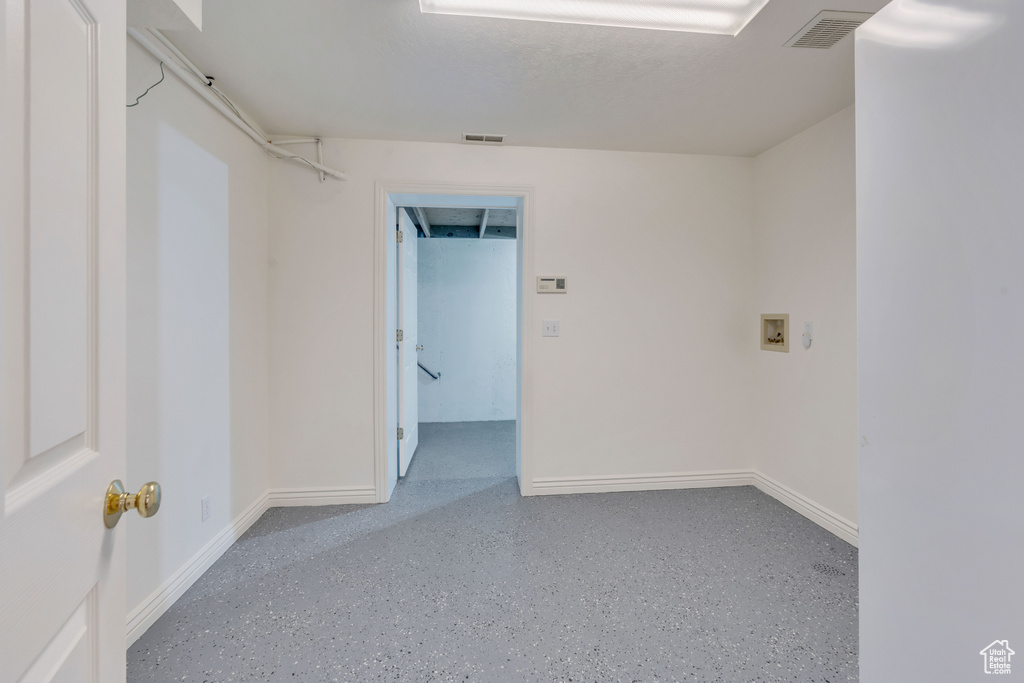 Empty room featuring baseboards and speckle patterned floor