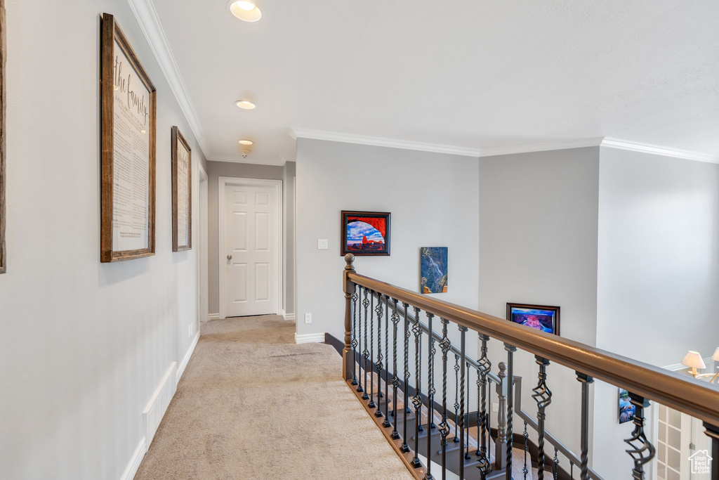Hallway with an upstairs landing, ornamental molding, carpet, and recessed lighting