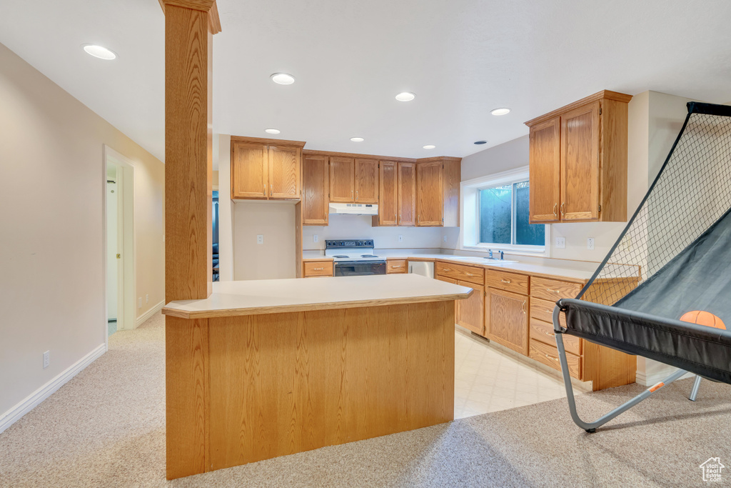 Kitchen featuring electric stove, under cabinet range hood, light countertops, recessed lighting, and a peninsula