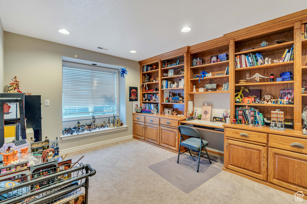 Office area featuring light colored carpet, built in desk, and recessed lighting