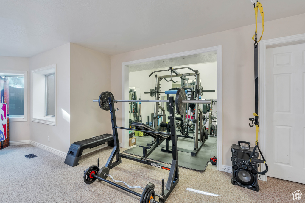 Exercise area with carpet floors and baseboards