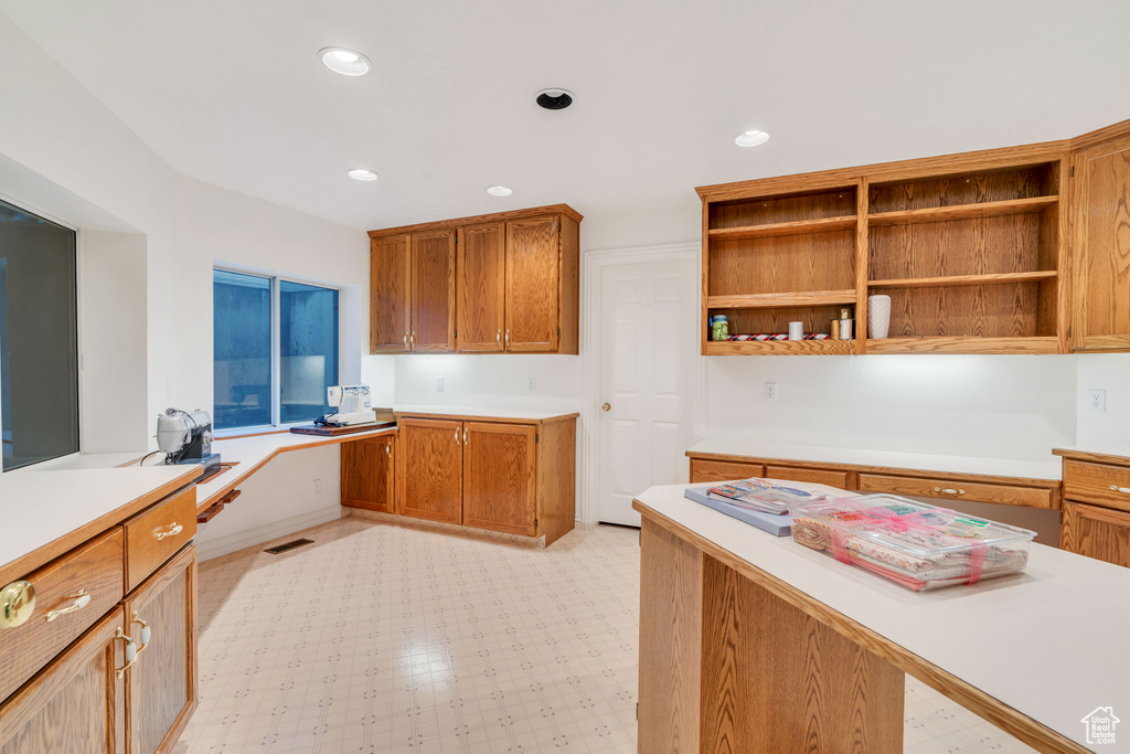 Kitchen featuring light countertops, open shelves, recessed lighting, and brown cabinetry
