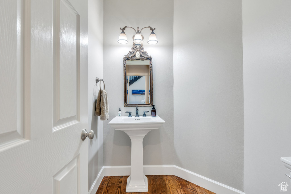 Half bathroom with baseboards and wood finished floors