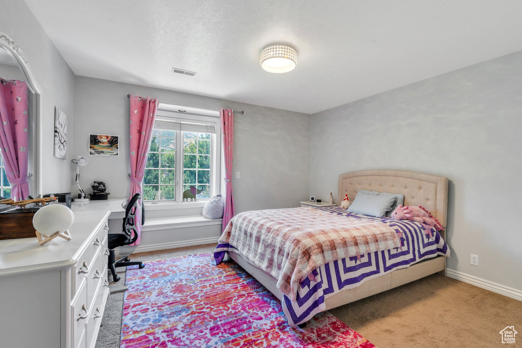 Bedroom with a desk and light colored carpet