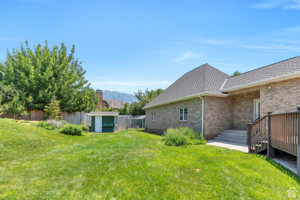 Fenced backyard featuring a storage shed and a mountain view