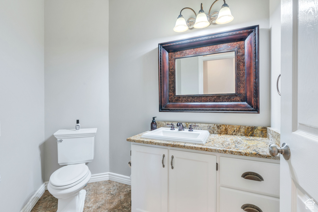 Half bathroom with baseboards and vanity