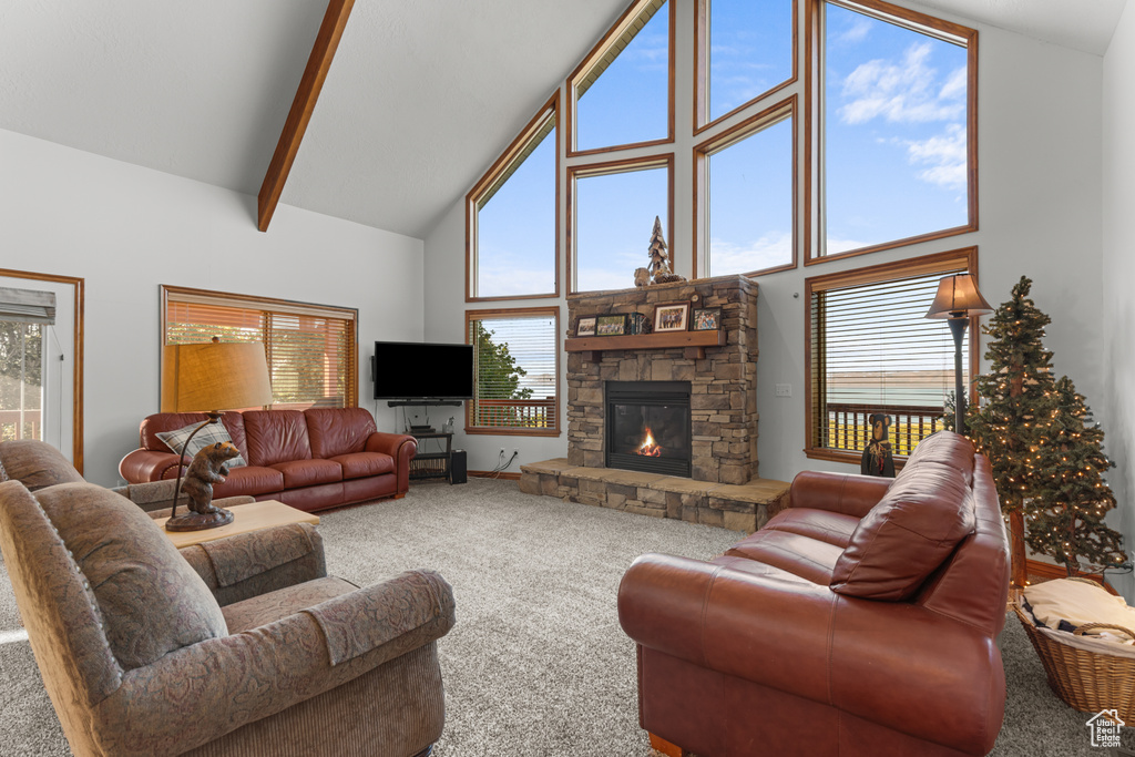 Carpeted living area with high vaulted ceiling, a fireplace, and beam ceiling