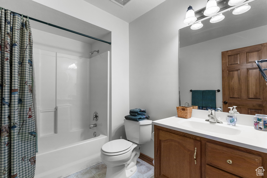 Full bath with shower / bath combo with shower curtain, vanity, and tile patterned flooring