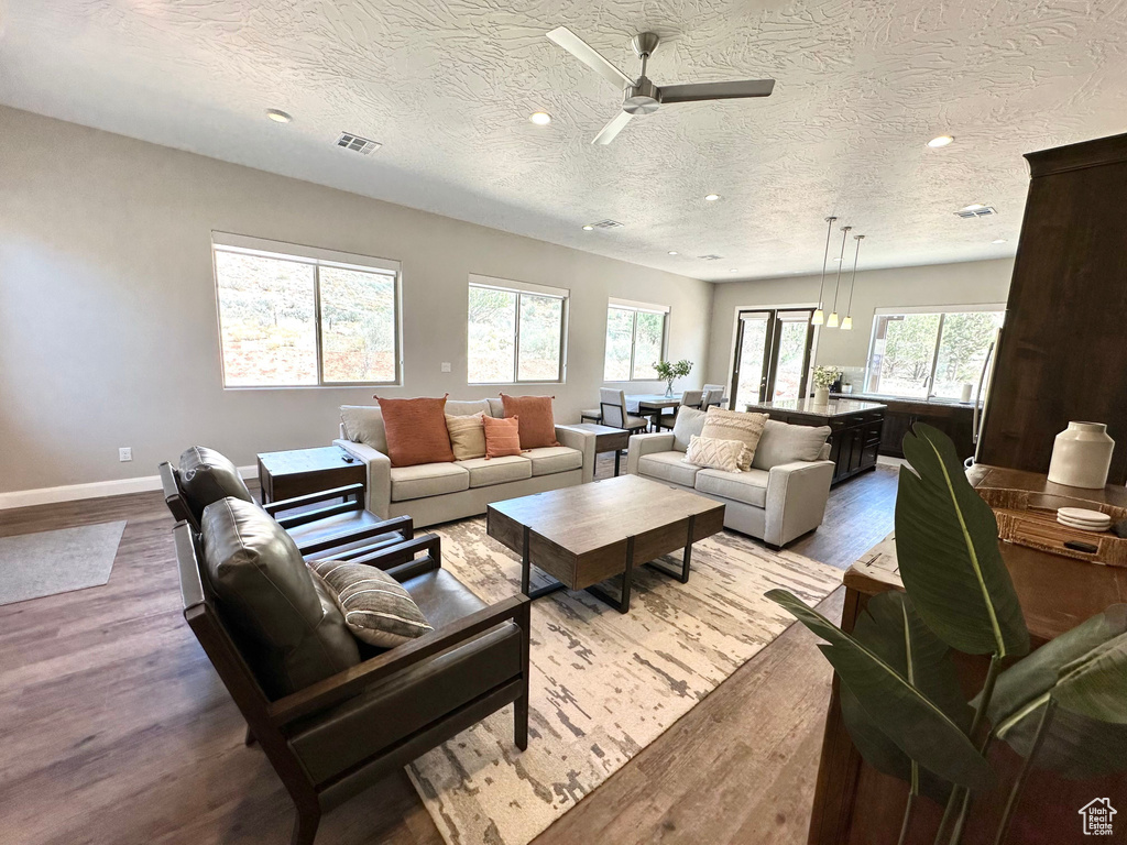 Living area featuring wood finished floors, recessed lighting, a textured ceiling, and a ceiling fan