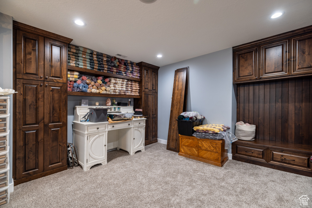 Office space with light carpet and recessed lighting