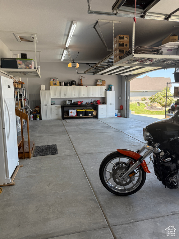 Garage with freestanding refrigerator and a garage door opener
