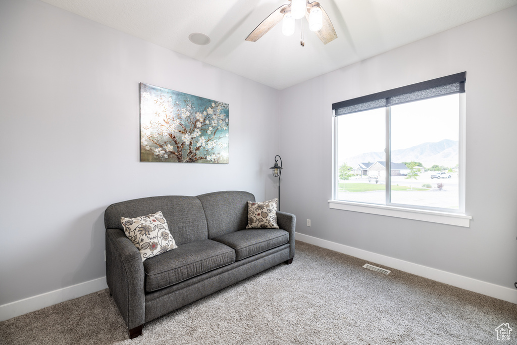 Sitting room with carpet floors, ceiling fan, and a mountain view