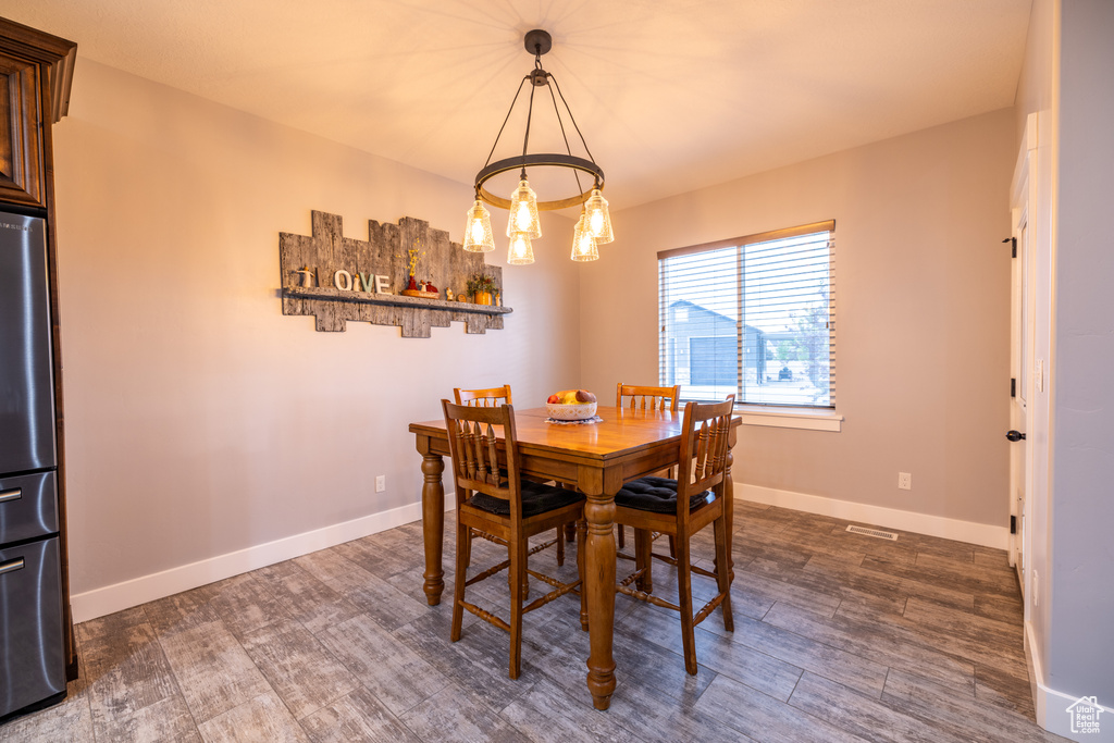 Dining area featuring dark wood finished floors and a chandelier