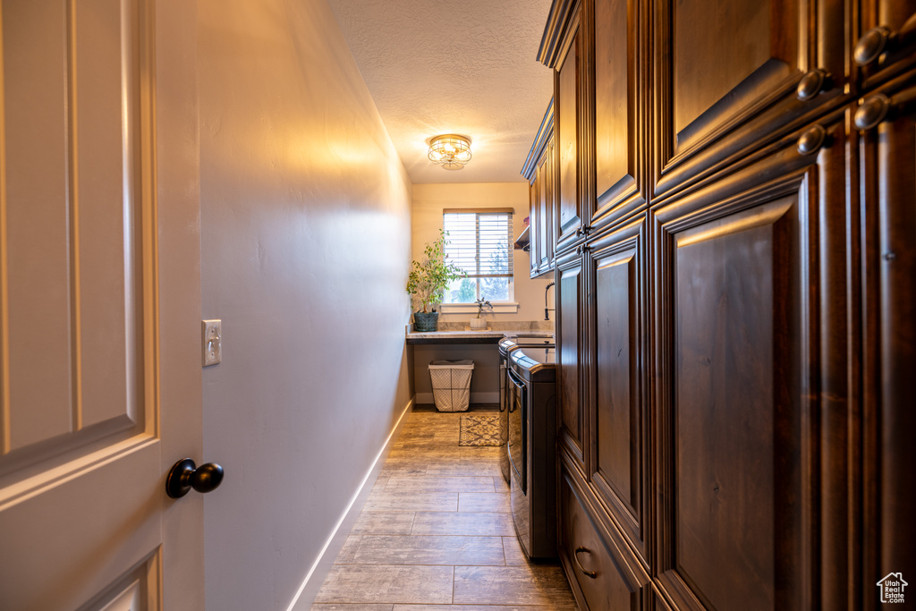 Kitchen featuring a textured ceiling, wood finished floors, and light countertops