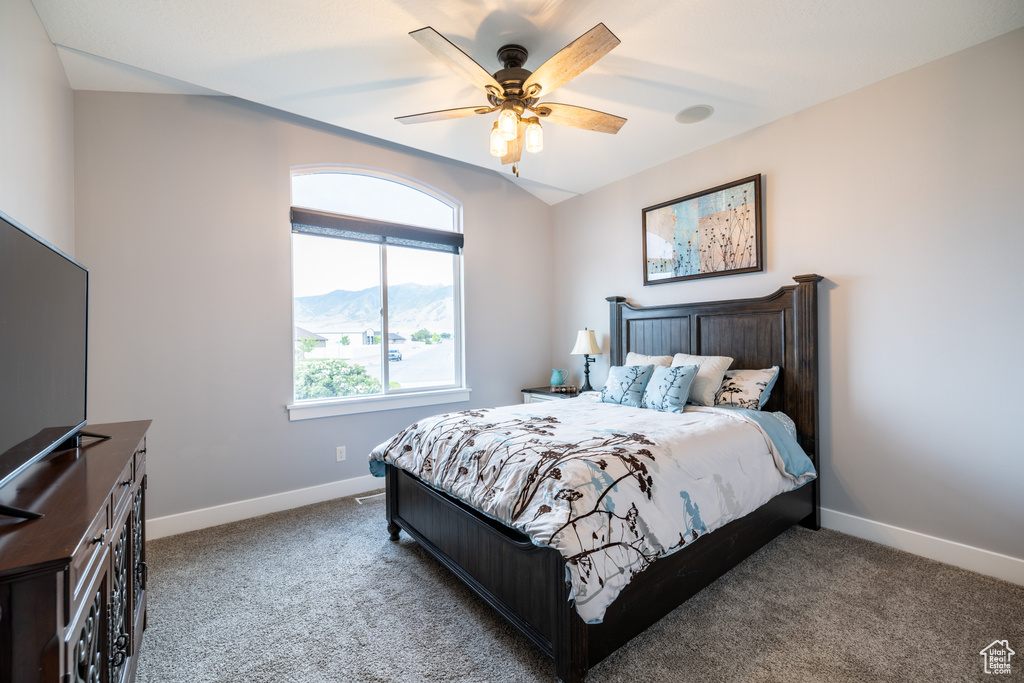 Bedroom featuring carpet flooring, a ceiling fan, and a mountain view