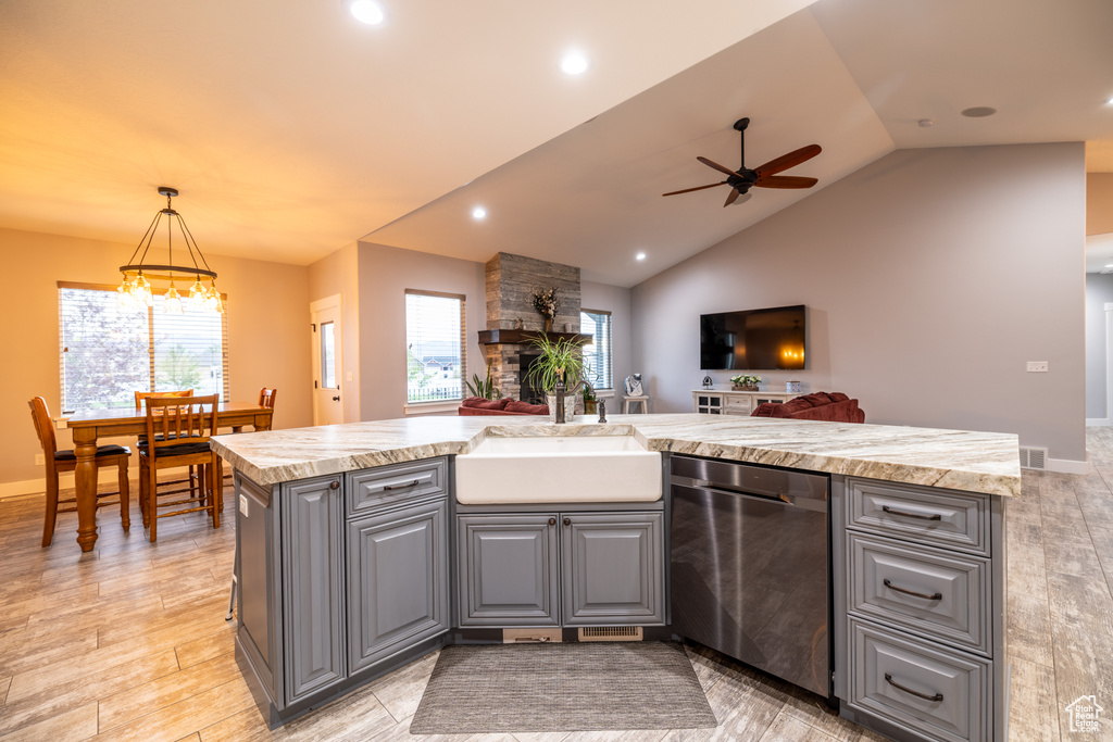 Kitchen with stainless steel dishwasher, gray cabinetry, light countertops, ceiling fan, and vaulted ceiling