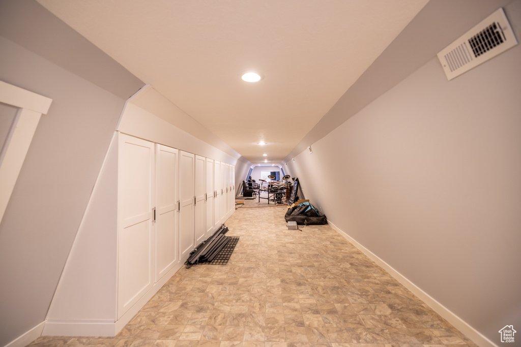 Exercise room featuring vaulted ceiling, recessed lighting, and stone finish flooring