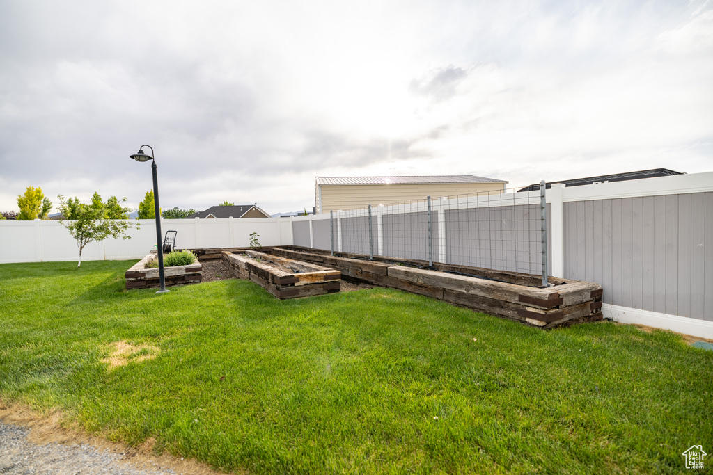 Fenced backyard featuring a vegetable garden