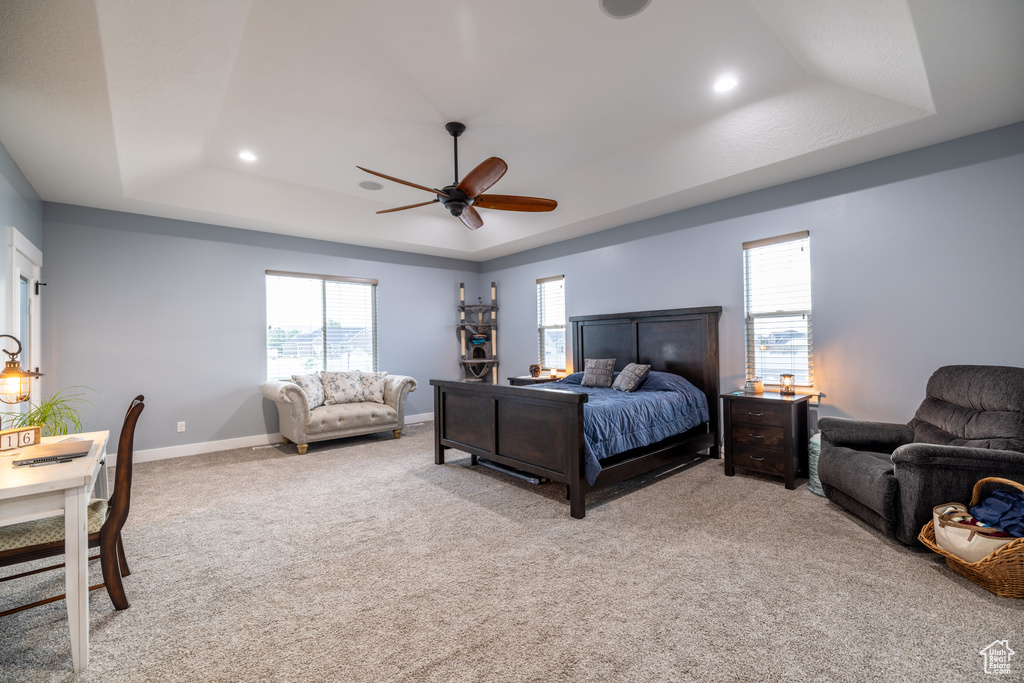 Bedroom with a tray ceiling, recessed lighting, light colored carpet, and ceiling fan