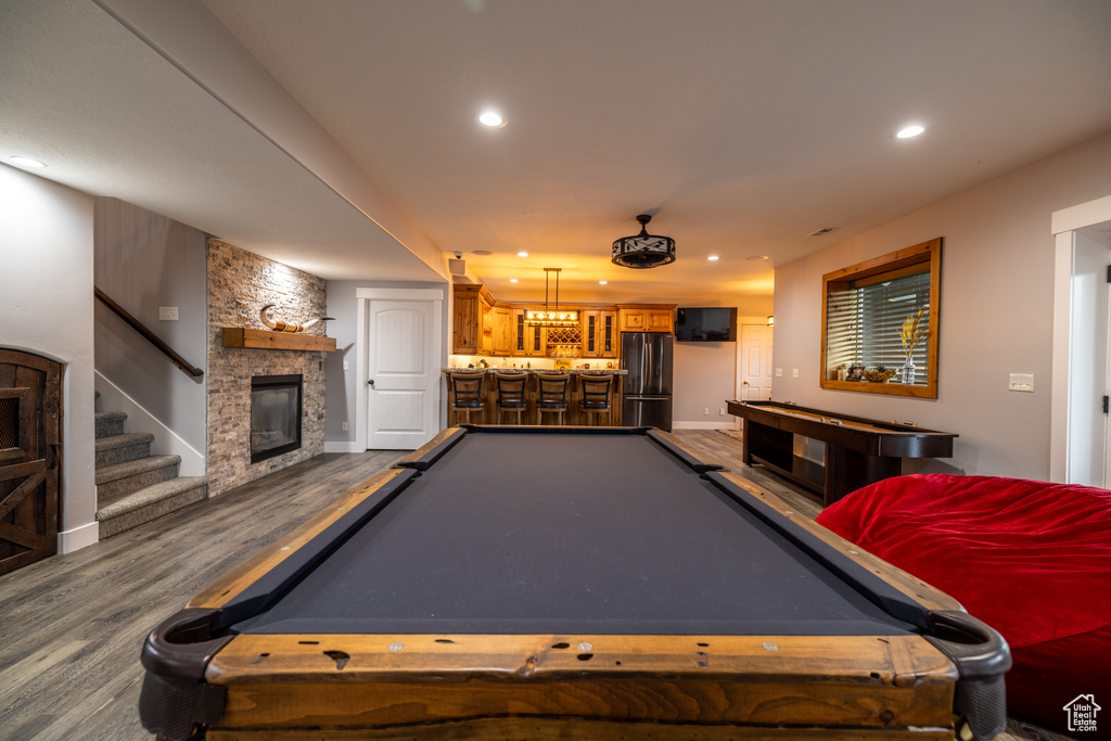 Game room with billiards, bar area, dark wood-style floors, recessed lighting, and a fireplace