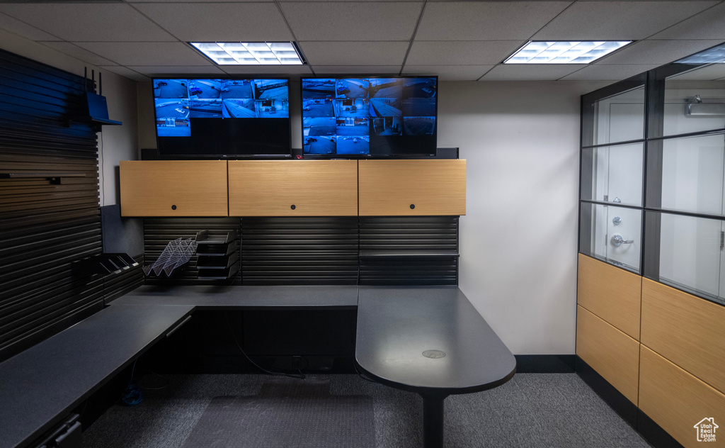 Misc room featuring a paneled ceiling, carpet flooring, and an office area
