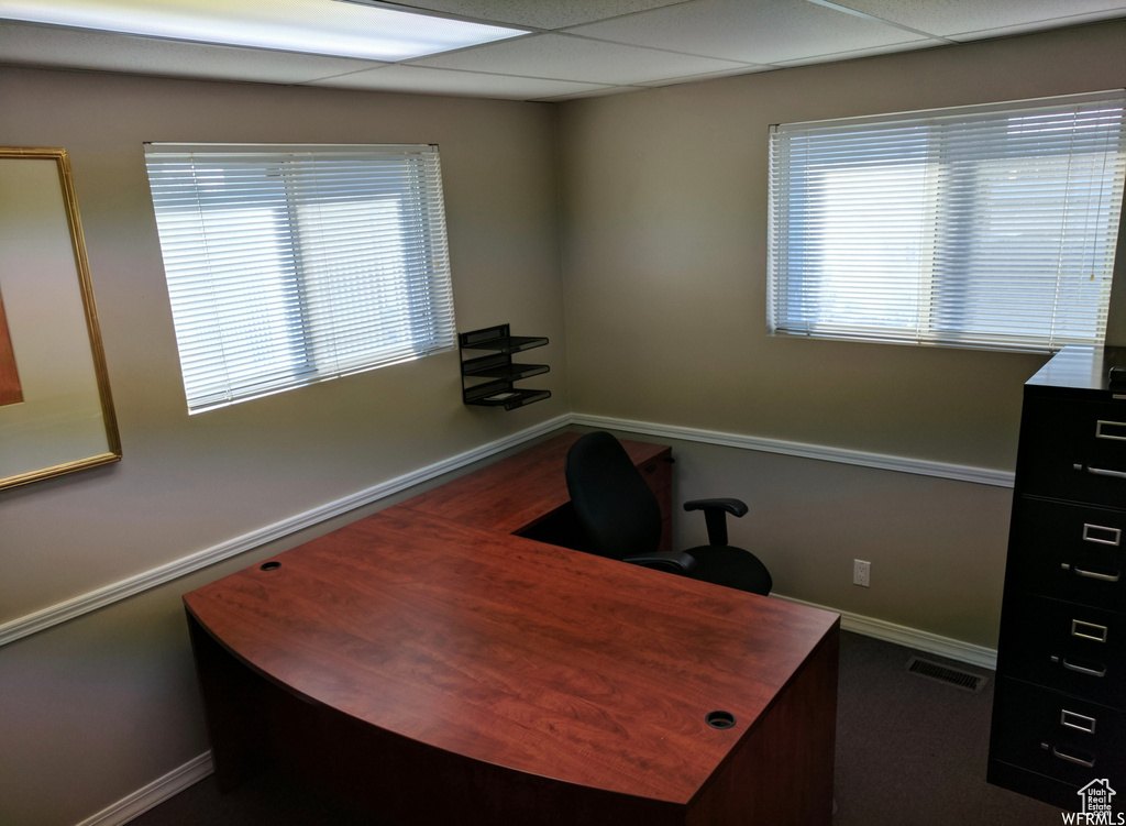 Office with baseboards and a drop ceiling