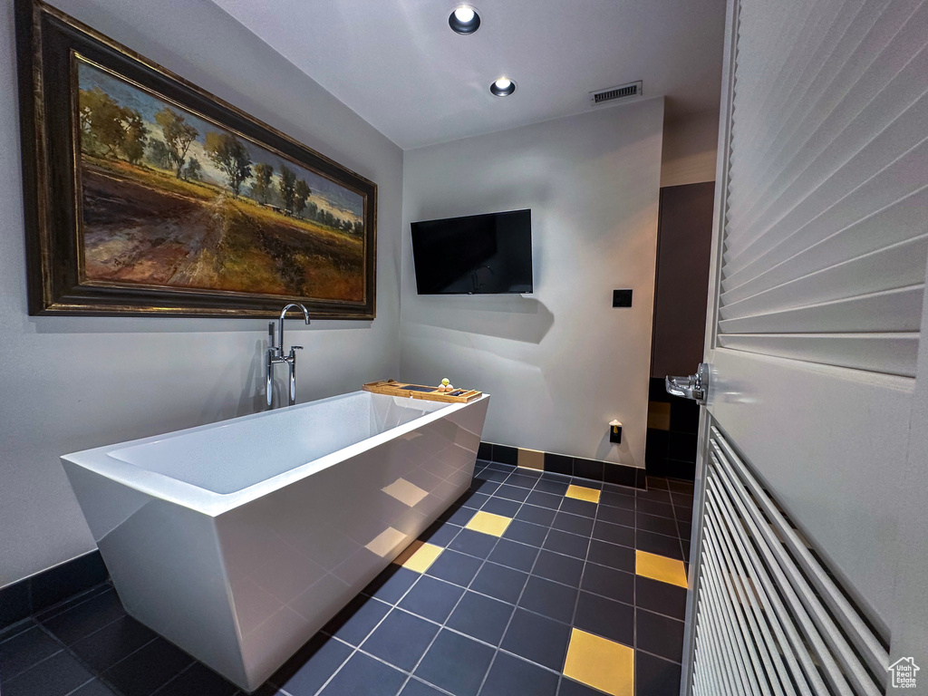 Bathroom with a freestanding bath, tile patterned floors, and recessed lighting