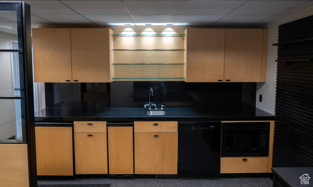 Kitchen with black appliances, a drop ceiling, dark countertops, and light brown cabinets