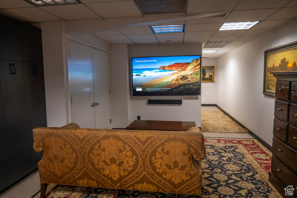 Cinema featuring a drop ceiling and baseboards