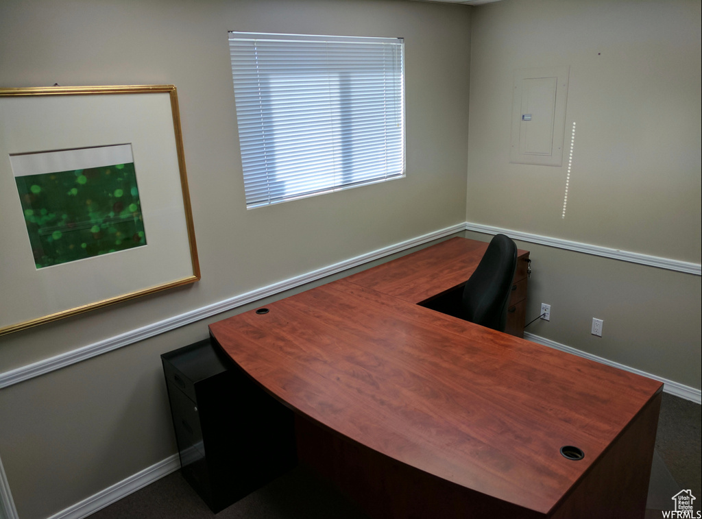 Office area with electric panel and baseboards