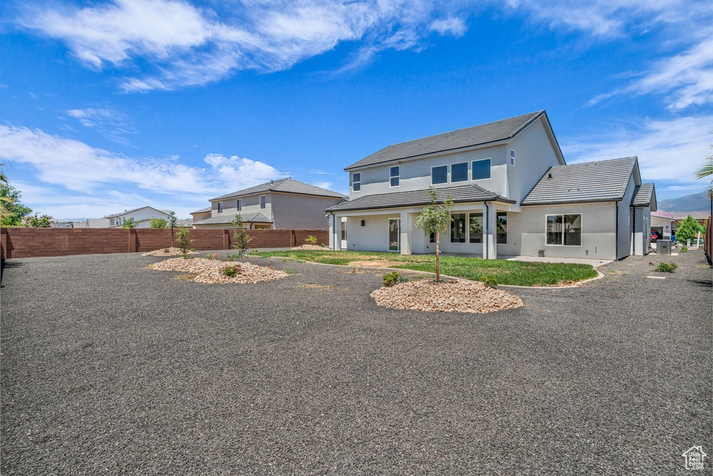 Back of property featuring stucco siding and a tile roof