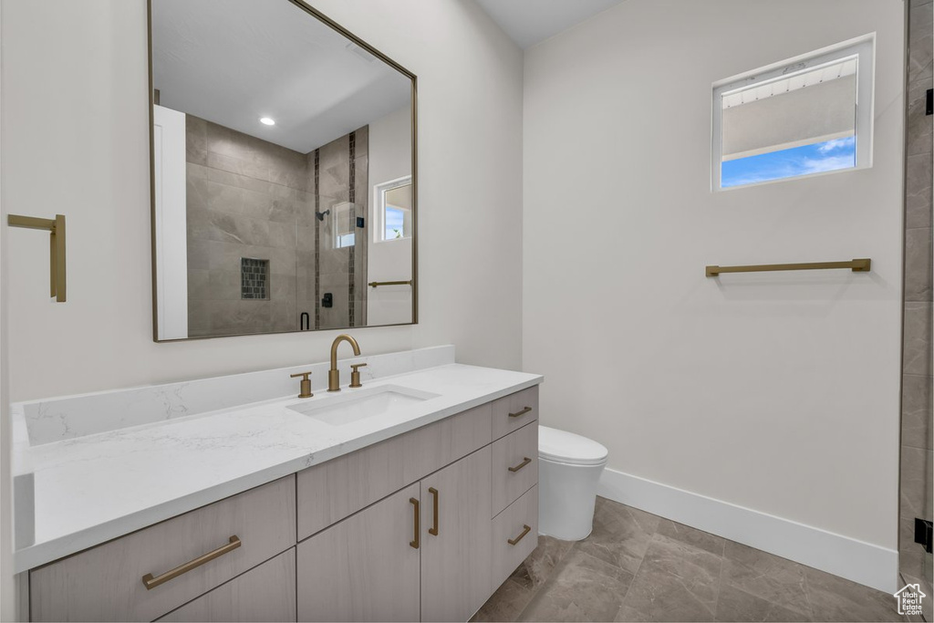 Full bathroom featuring vanity, marble finish floors, and a shower stall