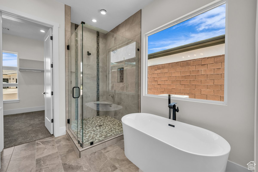 Full bath with a freestanding bath, a shower stall, and recessed lighting