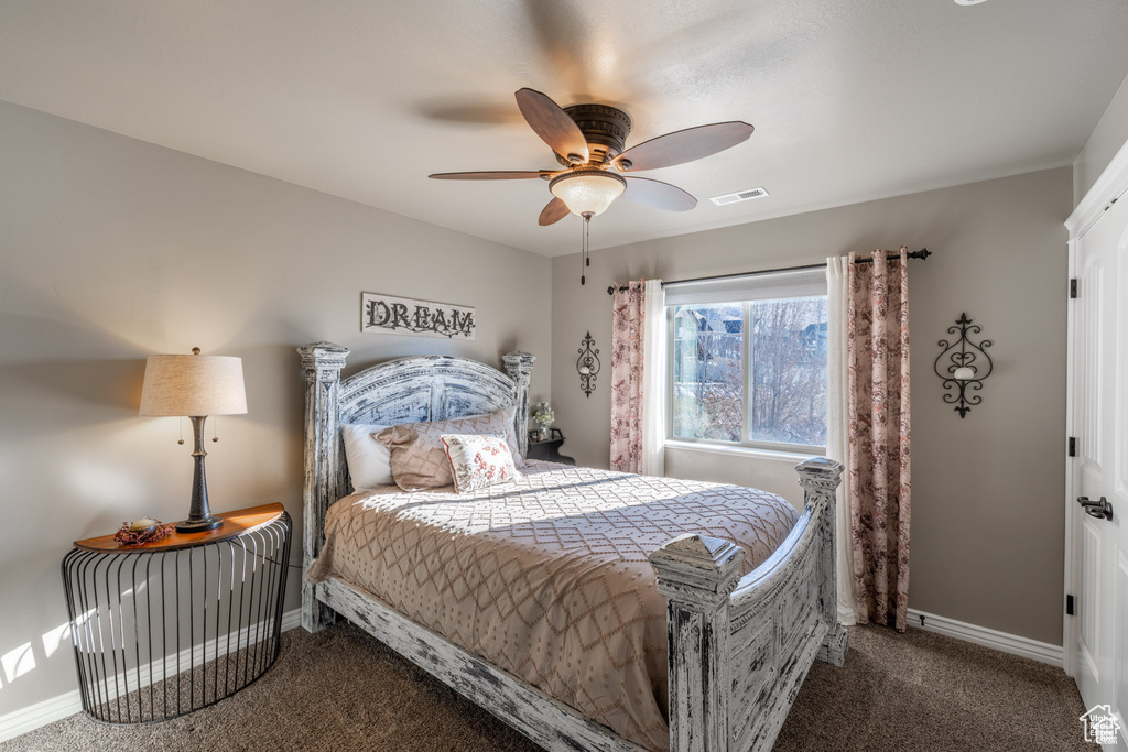 Carpeted bedroom featuring baseboards and ceiling fan
