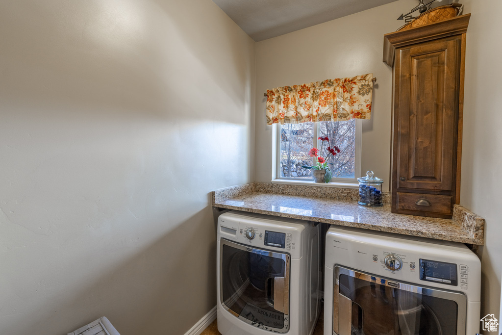 Washroom featuring independent washer and dryer and cabinet space